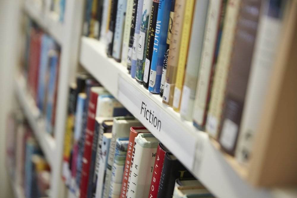A close-up photo of a bookshelf labeled Fiction.